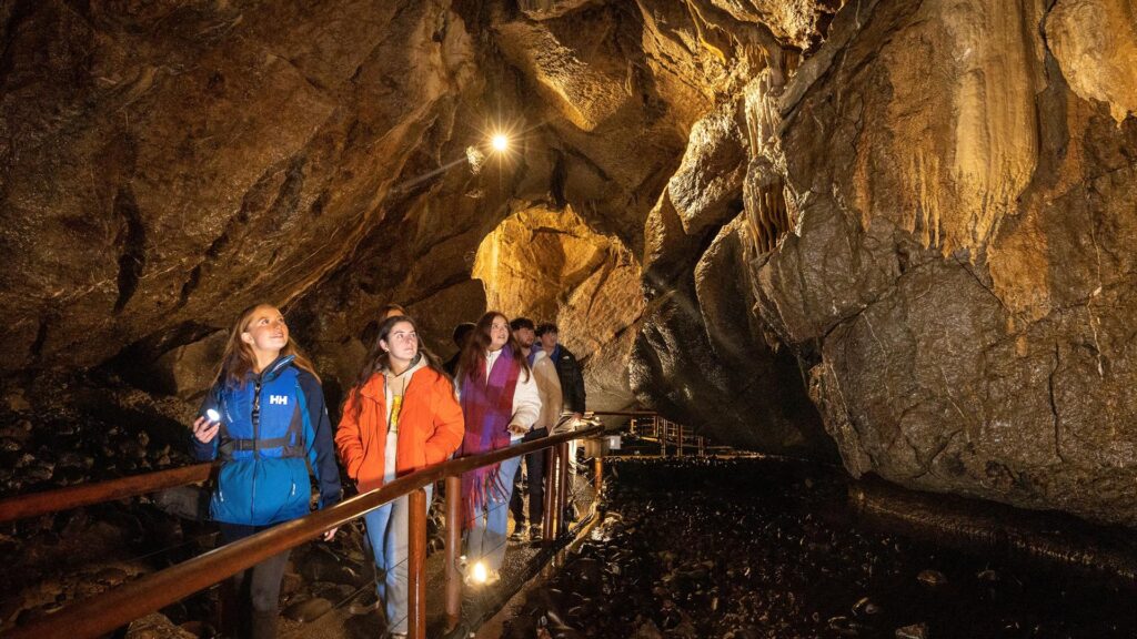 Visitors exploring Marble Arch Caves with rock formations and underground walkway in County Fermanagh