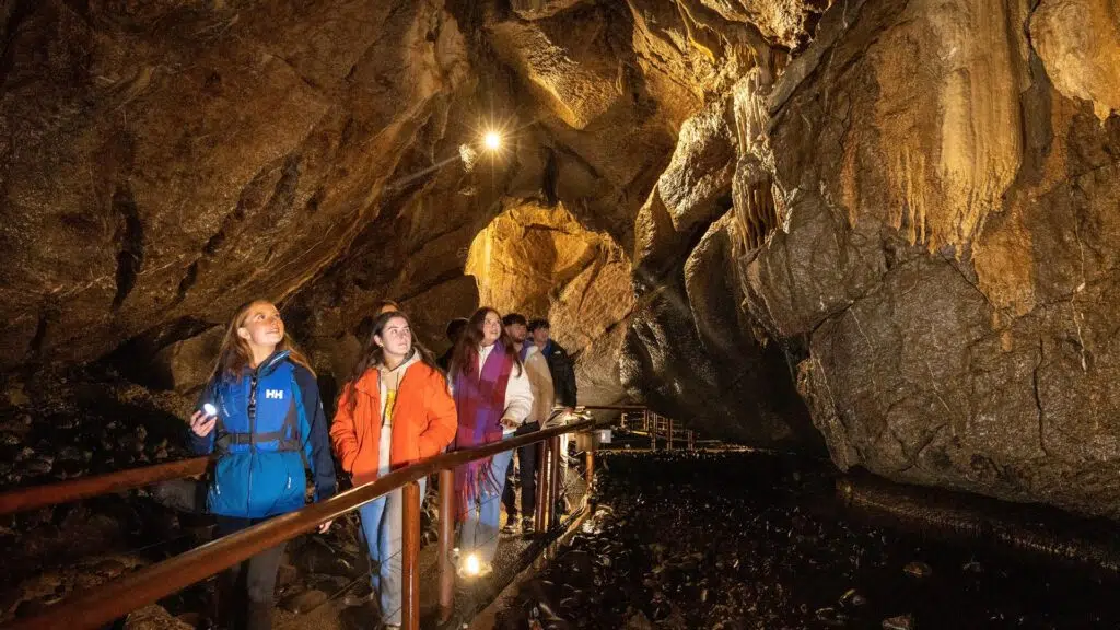 Visitors exploring Marble Arch Caves with rock formations and underground walkway in County Fermanagh