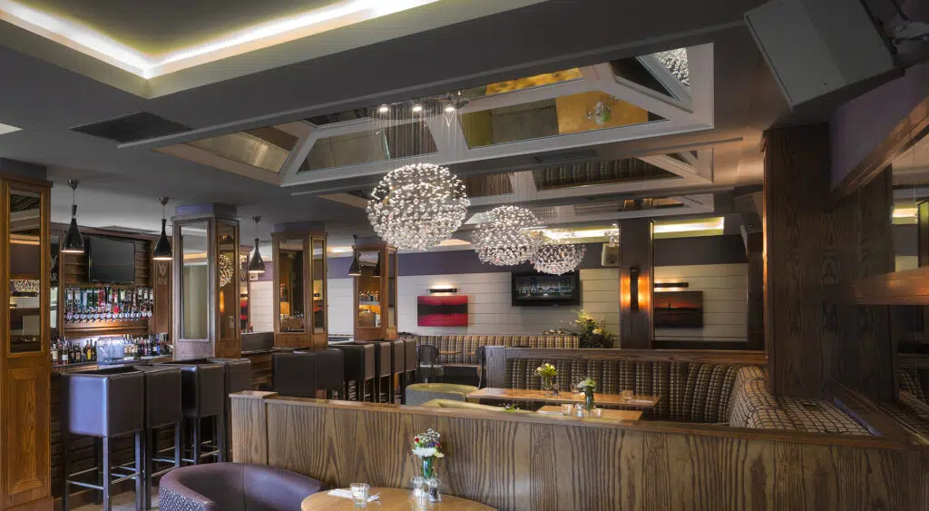 Stylish interior of the Westville Hotel bar with seating booths, chandeliers and modern lighting