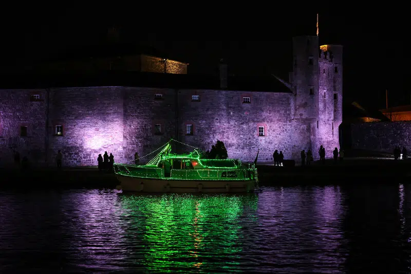 Illuminated boat passing Enniskillen Castle on the River Erne, Enniskillen, County Fermanagh.