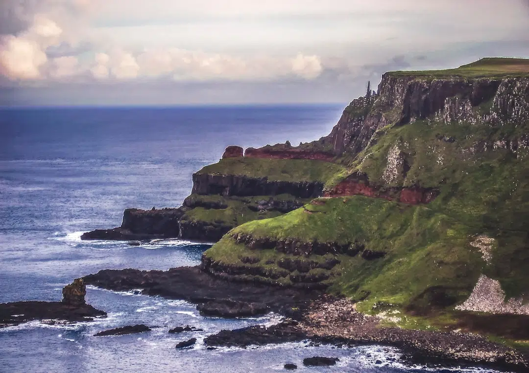 green and gray cliffs besides body of water Crafting Memorable Northern Ireland 2 Night Breaks