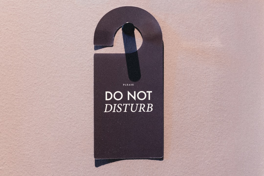 A dark "do not disturb" sign hangs on a wall. - lazy sunday hotel deals