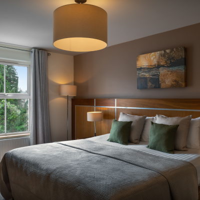 Modern guest bedroom at the Westville Hotel featuring a double bed, warm lighting and contemporary décor